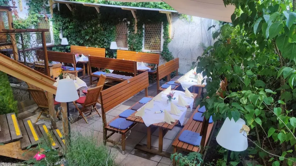 Weiße Tischdecken und feierliche Dekoration bei einer Hochzeitsfeier im Biergarten des Atelier Teufelsbäck.